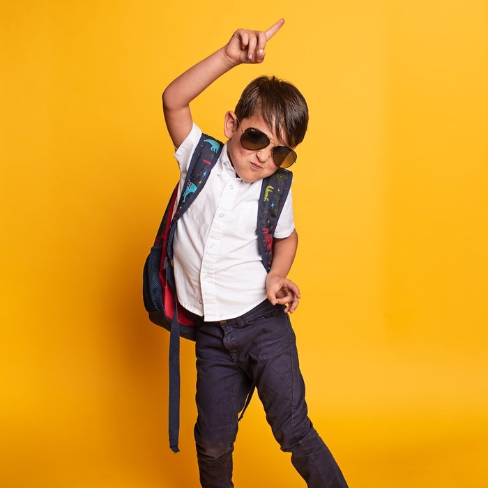 menino comemorando com a mochila nas costas