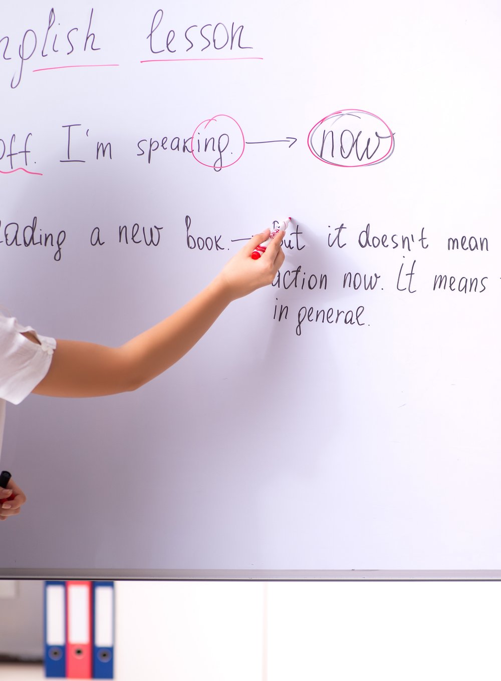 explicação de gramática escrita à mão no quadro durante uma aula